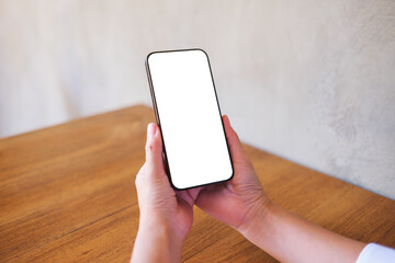 Wall Mural - mockup image of a woman holding black mobile phone with blank desktop screen