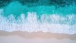 © wicha - A breathtaking aerial view of a vast turquoise ocean meeting a pristine white sandy beach, with gentle waves creating beautiful patterns along the shore