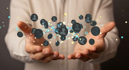 Poster - person holding a network of gray human icons in their hands with white shirt and blurred background