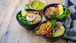 © Manuel - A vibrant vegan Buddha bowl filled with avocado, rice, edamame, lime, cabbage, and other fresh ingredients, topped with sesame seeds.