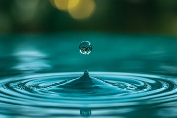 Poster - Teal water droplet falling, creating concentric ripples.  Symbolizes purity, serenity, and the natural world.  Perfect for calm, clean designs.
