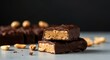 © Postmodern Studio - Chocolate-covered peanut butter bars with peanuts on a gray surface