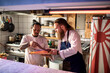 © Marko Geber - Two young male sushi chefs inspecting and preparing fish for a sushi dish in the kitchen of a japanese sushi restaurant