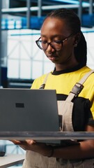 Poster - vertical video portrait of happy engineer in smart photovoltaics factory looking at system performan