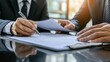 © Akstem - A businessman signs a contract with a pen, focusing on the paperwork process.