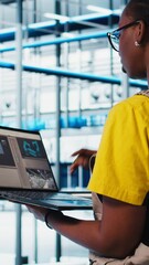 Poster - vertical video smart photovoltaics factory expert looking at system performance metrics on laptop so