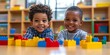 © Snap Essence - Adorable african american boys playing with construction blocks sitting on table at kindergarten