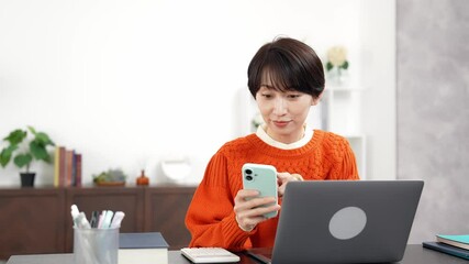 Leinwandbilder - スマホとノートパソコンを使うミドル女性