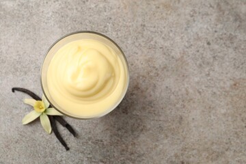 Wall Mural - Tasty vanilla pudding, pods and flower on grey table, top view. Space for text