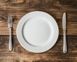 © Ririn Nadhiva - Place Setting Overhead with Plate Knife and Fork on Wood Table