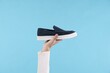 © New Africa - Man with stylish shoe on light blue background, closeup