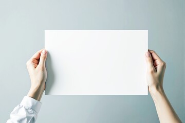 Poster - Hands holding blank white paper on light background.
