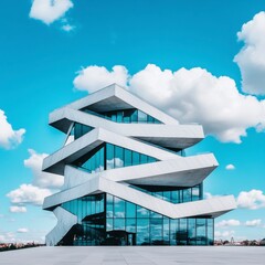 Poster - Modern white building with geometric design against a blue sky with fluffy clouds. The structure features glass windows and sharp angles.