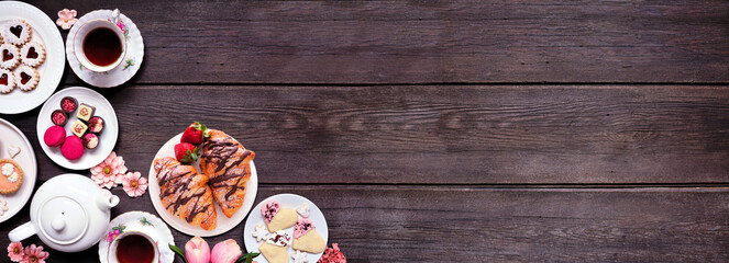 Leinwandbilder - Mother's Day tea corner border over a dark wood banner background. Assortment of sweet desserts and pastries. Top view. Pink flower and hearts theme.