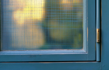 Poster - close up of blue window frame with screen mesh and blurry background for home design and architectur
