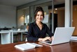 © Unlimited Resources - Confident Professional in Office: A poised and professional woman sits at her desk in a modern office, typing on her laptop with a captivating smile, symbolizing competence and approachability.