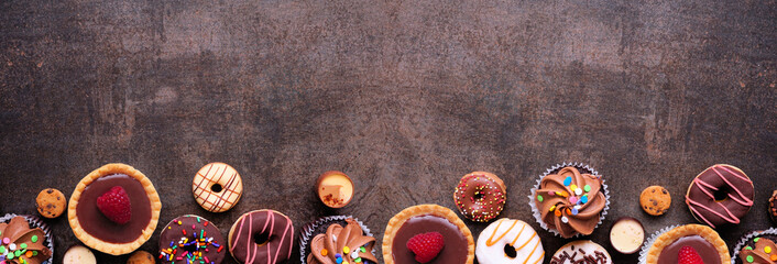 Aufkleber - Dessert bottom border with a collection of sweets. Top view on a dark stone banner background with copy space.