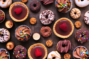 Leinwandbilder - Dessert background with a selection of sweets. Top view on a dark stone background.