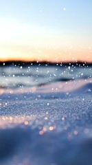 Poster - Sparkling snow crystals glisten against sunset sky, creating magical winter atmosphere with bokeh effect and soft pastel colors on frozen landscape at dusk.