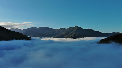 Wall Mural - aerial view of clouds and mountains at sunrise