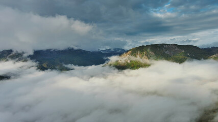 Wall Mural - aerial view of clouds and mountains at sunrise