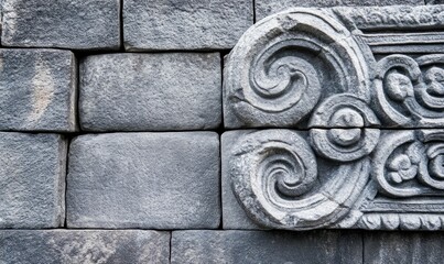 Poster - An ancient stone wall featuring intricate carvings and patterns showcases the beauty of historic architecture.