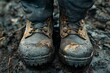 © ismail - Tar smudges on a pair of work boots, heavy and dark, representing the tough and resilient spirit of those who labor in challenging environments