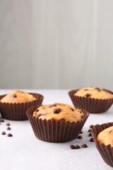 Wall Mural - delicious muffin with chocolate chips on light grey table, closeup