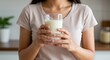 © JustFun - A Young South Asian Woman Holding a Glass of Milk in a Modern Kitchen, Showcasing a Healthy Lifestyle Choice and Emphasizing Nutritional Awareness