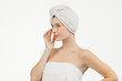© wedmoments.stock - Beautiful woman with blue eyes on a white background, with bandages under her eyes and a towel on her head. Self-care, spa and cosmetology concept.