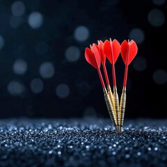 Poster - Close up of five red darts with gold tips, standing upright in a bed of dark, sparkling glitter against a black background with bokeh lights.