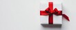 © Johanna - Minimalist gift box elegantly wrapped with a bright red ribbon on a pristine white background