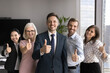 © fizkes - Happy group of diverse professionals looking at camera and showing like or thumbs up gesture. Satisfied clients giving recommendation of company services, making choice, positive feedback. HR, success