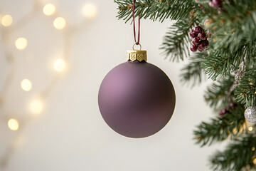 Poster - Purple glass Christmas ornament hanging on a fir branch against a bokeh background, symbolizing winter holidays, festive decoration, and celebration