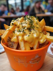 Aufkleber - Crispy fries topped with melted cheese sauce served in a vibrant orange container at a casual eatery