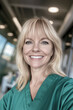 © larrui - A smiling female healthcare professional in green scrubs poses confidently in a modern medical facility, exuding warmth, professionalism, and positivity