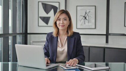 Poster - businesswoman using laptop in modern office setting