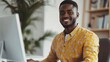 © Rastika - Smiling african american man working at computer in the home office setting