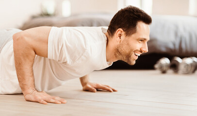 Aufkleber - Home Workout Concept. Happy Man Doing Plank Exercise Training Indoors On Weekend Morning.