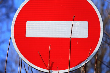 Poster - A close-up of a red and white sign with trees in the background.