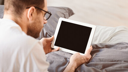 Aufkleber - Man Using Digital Tablet With Empty Screen Browsing Internet Lying In Bed In Bedroom At Home. Computer Blank Display For Application And Website Advertisement Concept. Panorama, Mockup