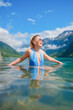 © biletskiyevgeniy - Happy girl swimming in a mountain lake in Norway. Vacation and travel. Nature in fjords. Mountains and reflections on the surface of the water. Scandinavia. Traveling on a Norwegian fjord.