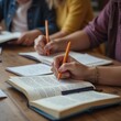 © Alex Pios - Close-up of hands holding books and notebooks during a literacy workshop, emphasizing the importance of reading materials in the learning process.