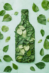 Wall Mural - over head flat lay view of a plastic bottle shape made from a leaves on a plain background