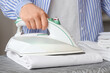 © Pixel-Shot - Woman ironing bed sheet on board, closeup