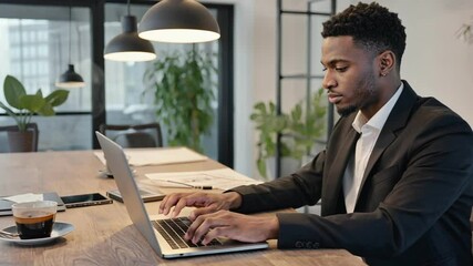 Wall Mural - Focused Professional at Work: A concentrated businessman, engrossed in his laptop, exemplifies modern business practices. The office setting is minimalist and professional
