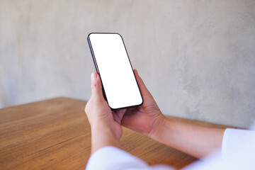 Wall Mural - mockup image of a woman holding black mobile phone with blank desktop screen