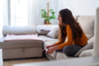© Javier Zayaz - Happy young woman holding a controller and playing videogames, sitting on a comfortable sofa in her living room