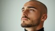 © Stella 16 - A man with a shaved head and a beard looking at the camera. The man has a serious expression on his face.