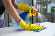 © zinkevych - Young woman in yellow gloves cleaning the table in the office